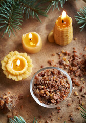 A bowl of myrrh resin with spruce branches and bees wax candles