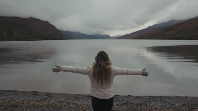 Backwards Woman raises hands up. Adult girl with freedom celebrates goals triumph. Landscape Magnificence. Slow motion