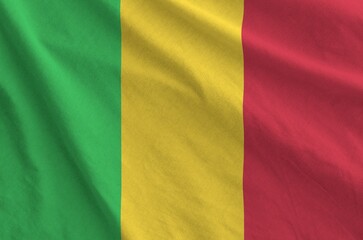 Mali flag depicted on folded wavy fabric of old cloth close up