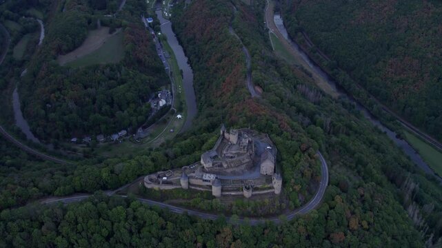 Aerial view of medieval castle surrounded by autumn trees and hills, Bourscheid, Luxembourg.