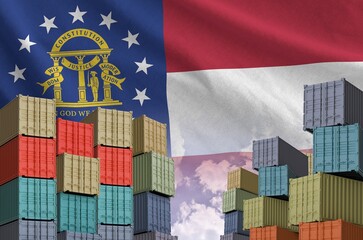 Georgia US state flag and big stack of shipping cargo containers in docks with sky background close...