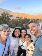Obraz premium A family of five is posing for a photo on a Huacachina Oasis. Peru