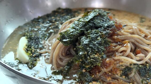 한국 강원도 강릉 동치미 막국수 국자로 차가운 국물 담는 모습