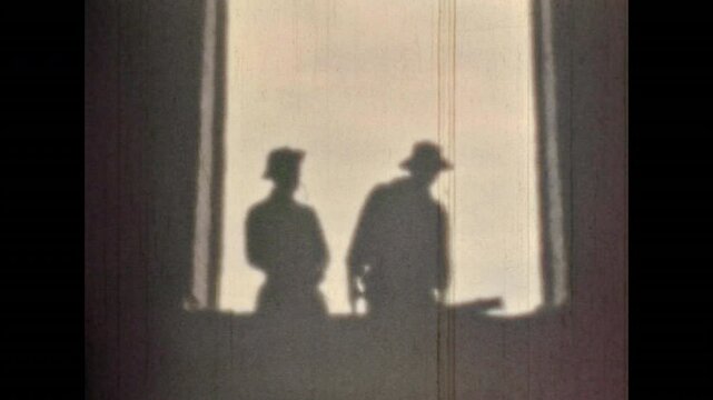 Men silhouettes, bad guy attacking, hitting cowboy in hat. Treason, betrayal of friend. Westerns bygone nostalgic. Dramatic killing scene of wild west movie. Vintage color film. Retro 1960s archive