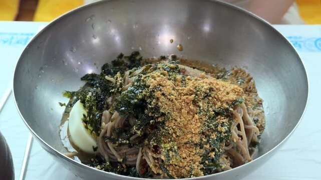 한국 강원도 강릉 동치미 막국수 국자로 차가운 국물 담는 모습