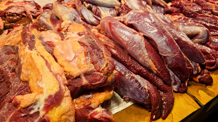 freshly butchered beef cuts on display at a local market stall, showing various textures