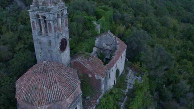 Aerial view of abandoned Catholic church ruins surrounded by forest and mountains, Prcanj, Kotor Bay, Montenegro.