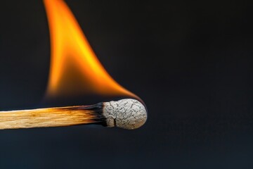 A close-up shot of a matchstick with flames licking at the background, ideal for illustrations on burning topics or fiery passion