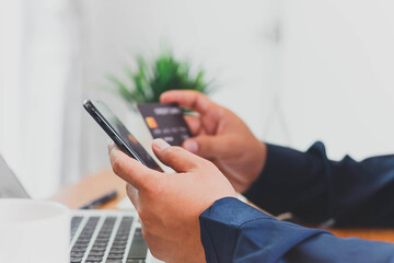 Close up Male hands holding credit card and smartphone, man paying online, credit card shopping, using banking service, entering information, shopping, ordering in internet store, doing secure payment