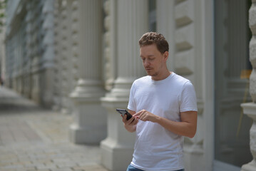 A man on the street using a smartphone. Concept of communication in social networks and messengers.