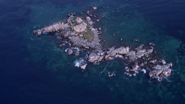 Aerial view of serene church and island on rocky coast at sunset, Petrovac, Montenegro.