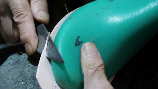 Bootmaker drive in nails in a shoe at the private workshop. Shoe making process