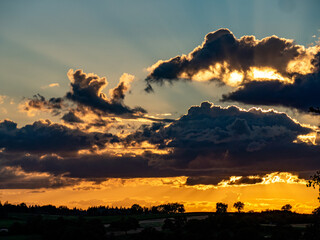 Sonne dringt durch dunkle Wolken am Abend