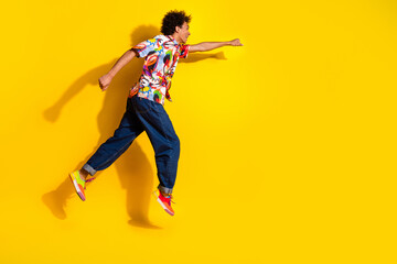Obraz premium Full body portrait of nice funky young man run jump empty space wear shirt isolated on vibrant yellow color background