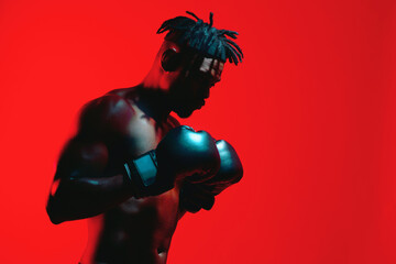 Red neon, black man and boxing gloves in studio background for sports match. Mockup space, sportsman and athlete with training, workout and exercise with fitness for competition and defence as boxer