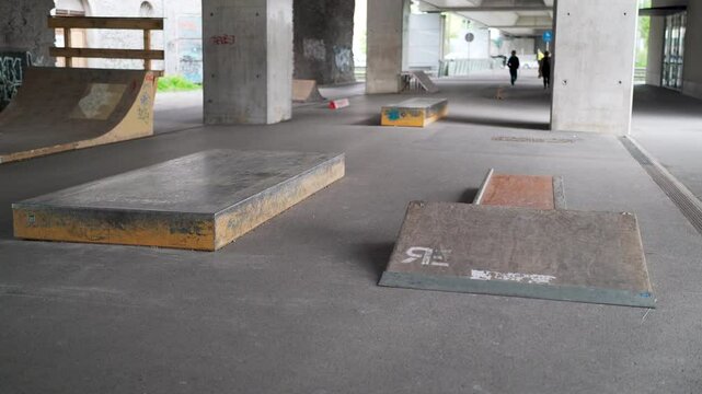 DIY skateboard park obstacles under a bridge