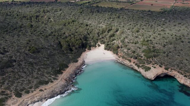 Aerial view of serene beach and clear blue water in Cala Varques, Mallorca, Spain.