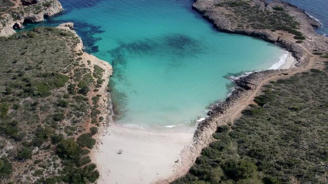 Aerial view of turquoise water beach with rock formations in Cala Varques, Mallorca, Spain.
