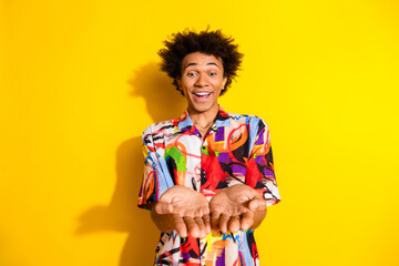 Portrait of nice young man hold empty space wear shirt isolated on vivid yellow color background