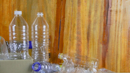 Waste plastic bottles on wooden background waiting for recycling concept of saving our environment sustainable natural resources.