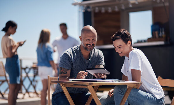 Colleagues, tablet and reading with smile, outdoor and review of statement for small business in summer. Partner, man and check for bills of store, paperwork and working on table and food truck - Powered by Adobe