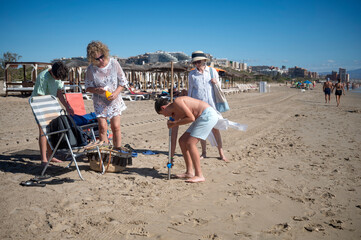 three generations family setting up for a day at the Mediterranean beach