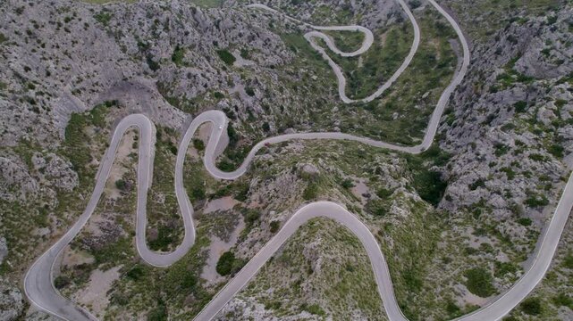 Aerial view of winding road and rocky terrain in Coll dels Reis, Mallorca, Spain.