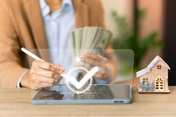 businessman holds pen, ticks, approves,reviews business documents, pile of money and house, concept,investment,real estate,and home mortgage, and online deals,savings,financial freedom,equipment Move.