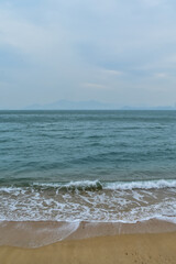 Close-up of soft waves sand beach and blue sea. Texture of water, white foam waves. Seascape, Sea background, Sea water with copy space, summer vacation concept. 