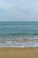 Close-up of soft waves sand beach and blue sea. Texture of water, white foam waves. Seascape, Sea background, Sea water with copy space, summer vacation concept. 