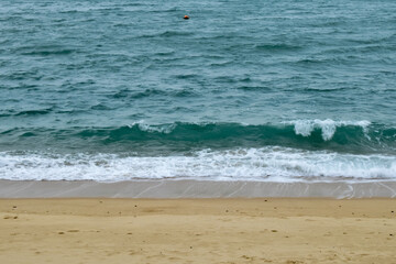 Close-up of soft waves sand beach and blue sea. Texture of water, white foam waves. Seascape, Sea background, Sea water with copy space, summer vacation concept. 