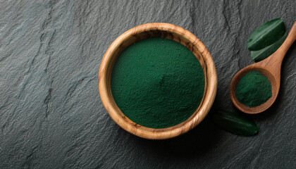 Green spirulina powder on wooden bowl on stone table. Healthy nutritional supplement