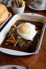 Lomo saltado with fried egg on a tray Peruvian breakfast food table