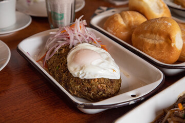 Tacu tacu with fried egg Peruvian breakfast food table with lomo saltado and pejerrey sandwich