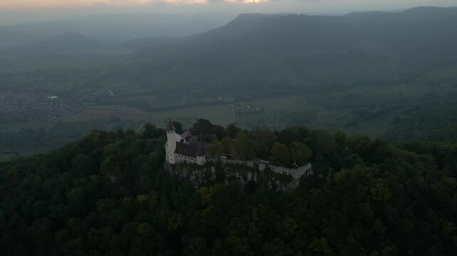 Aerial view of castle, mountain, forest, and valley during sunrise in Swabian Alps, Burg Teck, Germany.
