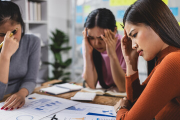 Group of Asian female employees and coworkers in a meeting are stressed in the conference room. Co-workers who are at a loss for ideas.