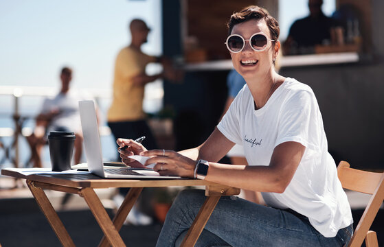 Portrait, smile and woman with laptop, outdoor and cafe in morning for scriptwriter with sunglasses. Summer, cheerful and happy with computer, coffee and paper for inspiration, web and creative