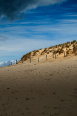Dramatic Coastal Sand Dune with Dark Clouds and Blue Sky, Łeba, Baltic Sea, Poland, Summertime