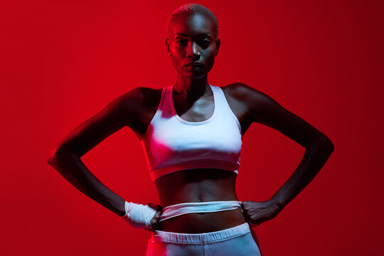 Black woman, portrait and confidence in studio for fitness with health, gym aesthetic and strong body. African athlete, boxer lady and pride for exercise, training and light filter by red background - Powered by Adobe