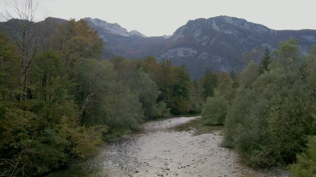Aerial view of majestic mountains, river, and forest in Ukanc, Bohinj, Slovenia.