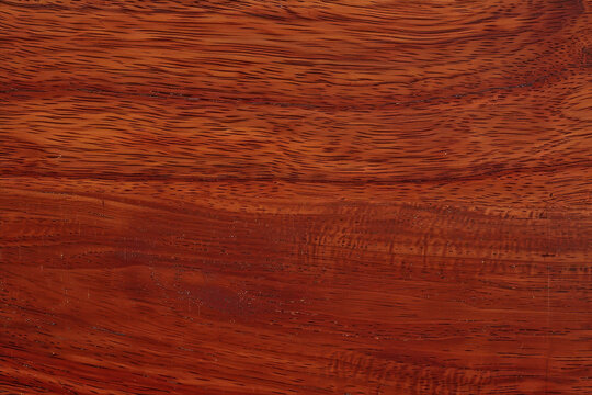 Sapele wood grain features a vibrant, reddish-brown hue with a unique, interlocking texture that creates a striking visual effect, often used for fine furniture and cabinetry due to its durability 