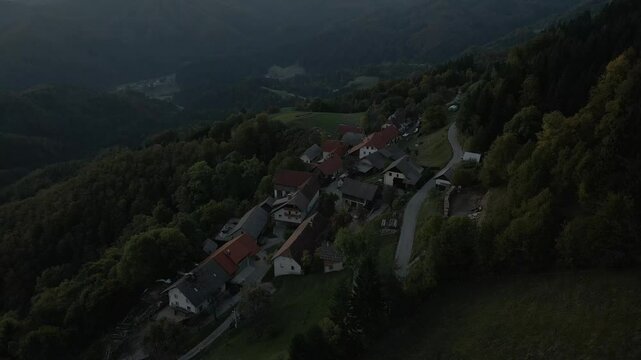Aerial view of village with mountain backdrop and winding road, St. Primoz Church, Julian Alps, Slovenia.