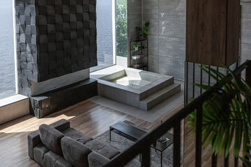 stylish minimalistic restrained modern interior of the apartment, a spacious room with a swimming pool, large panoramic windows overlooking the mountains. without people in the daytime