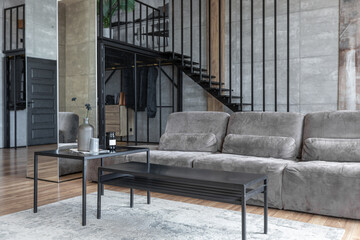 stylish minimalistic restrained modern interior of a two-storey apartment without people in the daytime in loft style in gray tones.