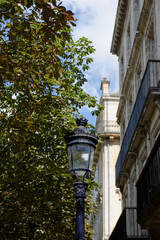 Lampadaire en centre ville avec feuillage en arri&egrave;re plan