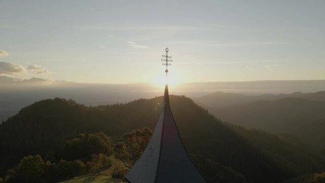 Aerial view of St. Primoz church at sunrise with mountain peaks in Julian Alps, Jamnik, Slovenia.