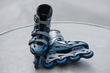 old blue roller skates lying in skate park