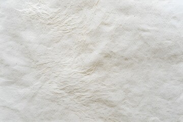 A close-up of the texture on an off-white paper background, with subtle grain and color variations that suggest its softness. The background is plain without any text or graphics.