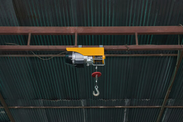 electric rope hoist hanging from roof structure., 