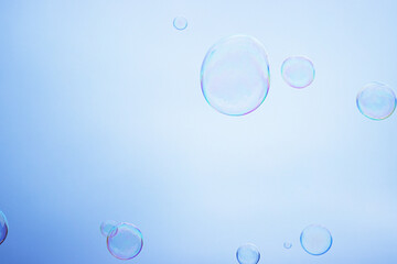Large multicolored soap bubbles flying in the cloudy sky. Big bubble outdoors in the spring or summer street. Many bubbles isolated on white background. Simple creative concept. Close-up. Copy space